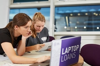 Image of two female students working on a university laptop