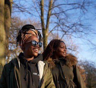 Two women on campus smiling in the sun